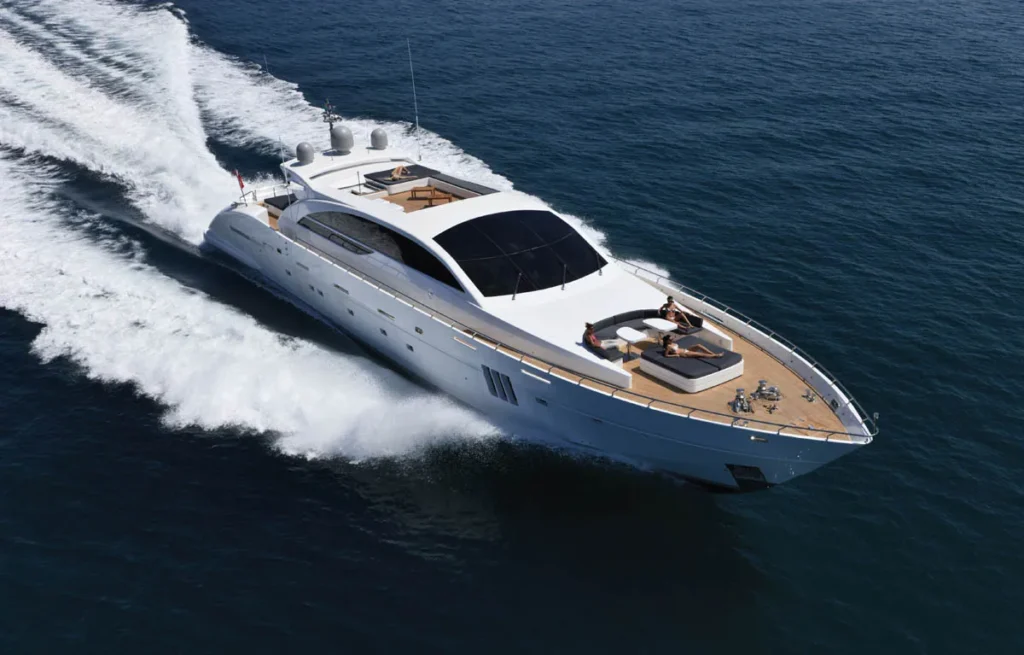 White Luxury Yacht Speeding Through Deep Blue Water with a Foamy Wake Behind It Viewed from Above