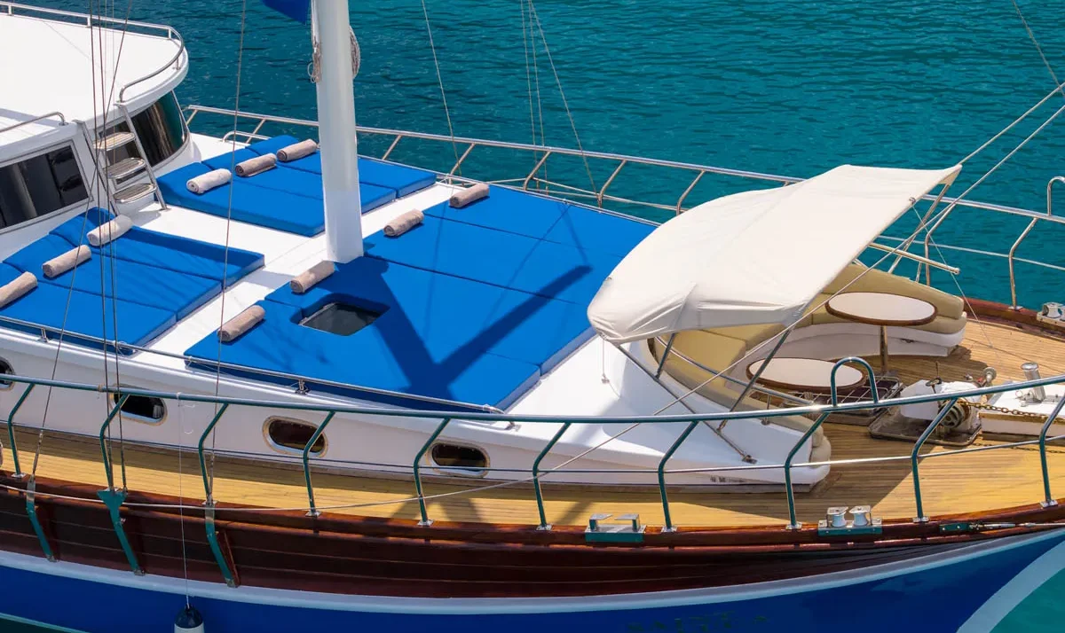 Blue-cushioned deck lounging area on a gulet Saint Luca in calm turquoise water