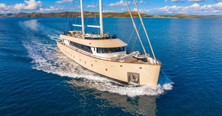 Maxita Luxury Private Yacht Charter Croatia-Luxurious beige motor yacht Maxita cruising in bright blue ocean with a distant island coastline.